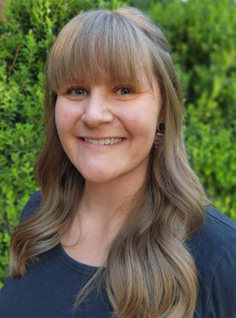 A person with long hair smilingAI-generated content may be incorrect.